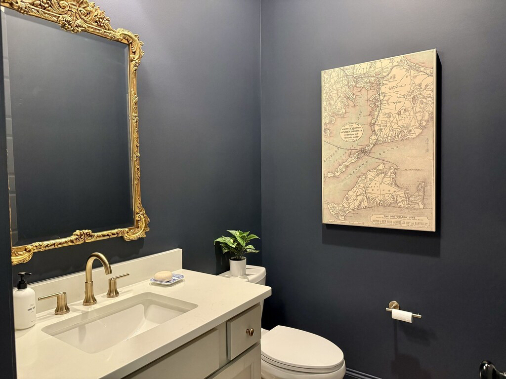Powder bathroom with a pedestal sink and framed mirror