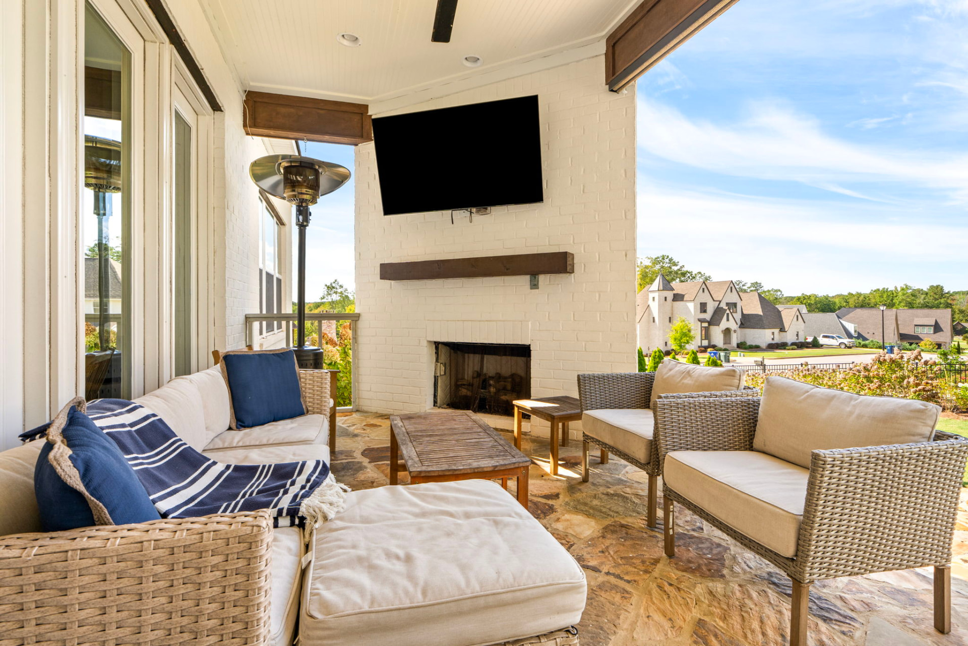 Stone patio with outdoor seating behind The Hydrangea House